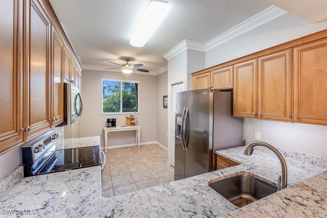 8251 Pathfinder Loop, Unit 615 Fort Myers, FL 33919 - Photo 5 of 44 a kitchen with stainless steel appliances granite countertop a refrigerator a stove and white cabinets with wooden floor