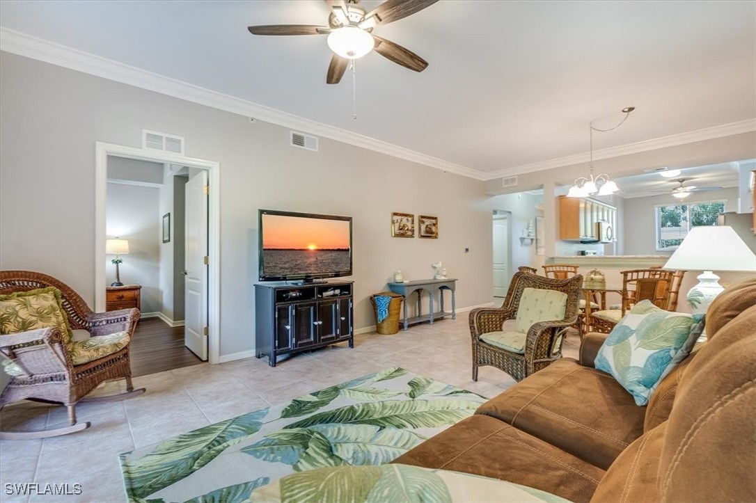 8251 Pathfinder Loop, Unit 615 Fort Myers, FL 33919 - Photo 9 of 44 a living room with furniture and a flat screen tv with kitchen view