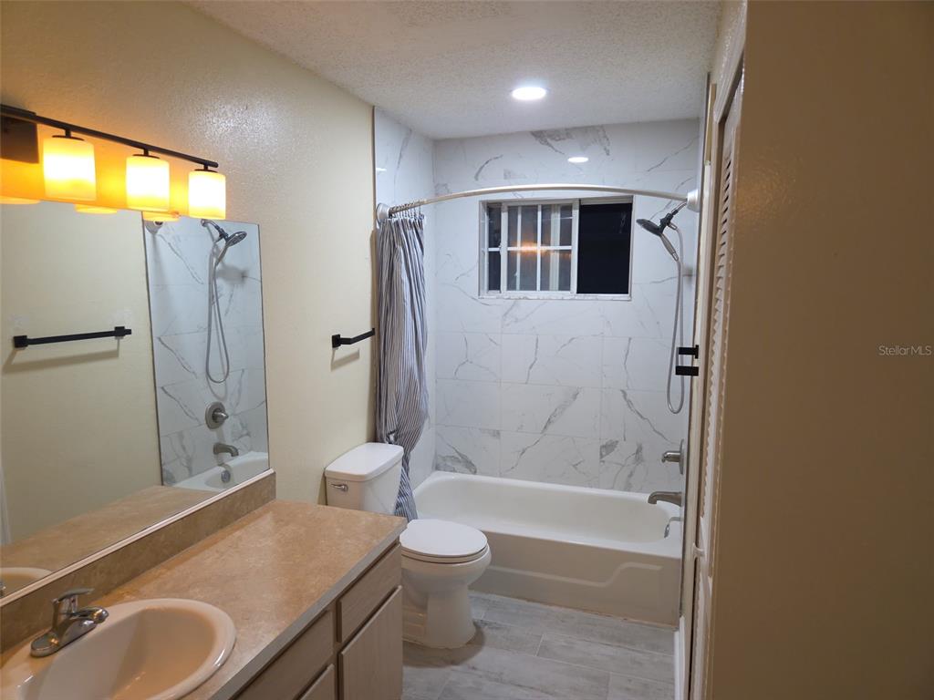 3705 Southwest 27th Street, Unit 422 Gainesville, FL 32608 - Photo 23 of 25 a bathroom with a granite countertop sink toilet and shower