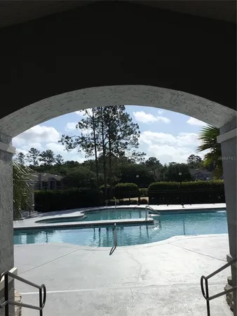 a view of swimming pool with seating space and lake view