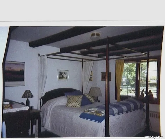 a bed sitting in a bedroom next to a window