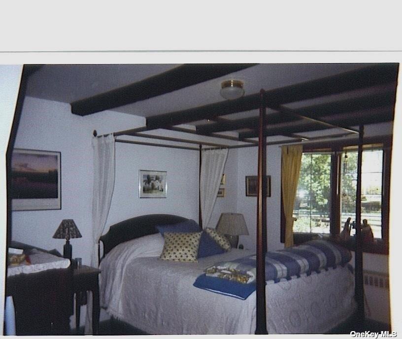 165 Sterling Street Greenport, NY 11944 - Photo 11 of 18 a bed sitting in a bedroom next to a window