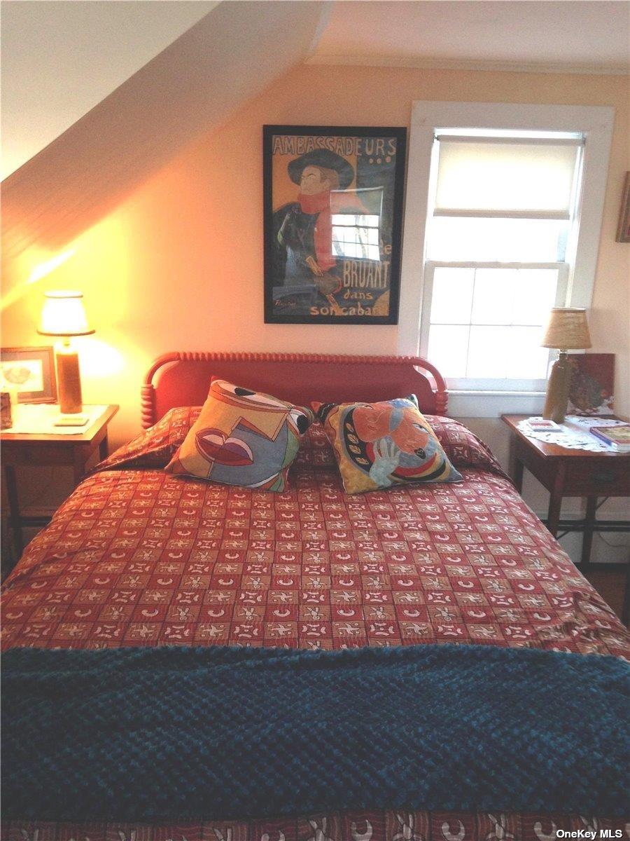 165 Sterling Street Greenport, NY 11944 - Photo 12 of 18 a bedroom with a bed and wooden floor