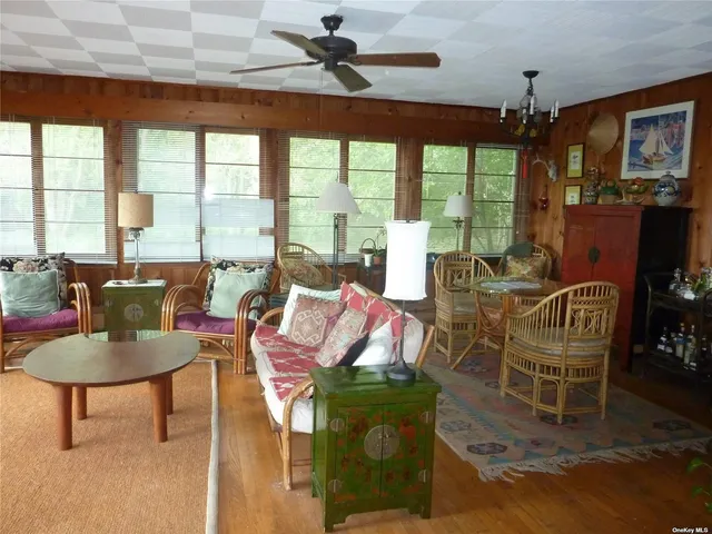 a living room with furniture a chandelier and a floor to ceiling window