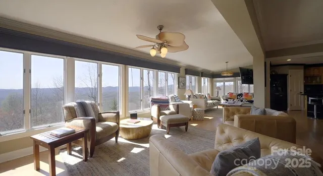 a living room with furniture ceiling fan and a large window