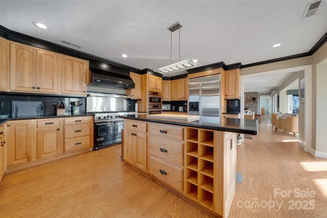 a kitchen with stainless steel appliances granite countertop a sink a stove and a cabinets