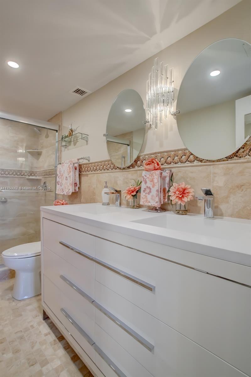 1505 North Riverside Drive, Unit 604 Pompano Beach, FL 33062 - Photo 35 of 50 a bathroom with a toilet sink and mirror