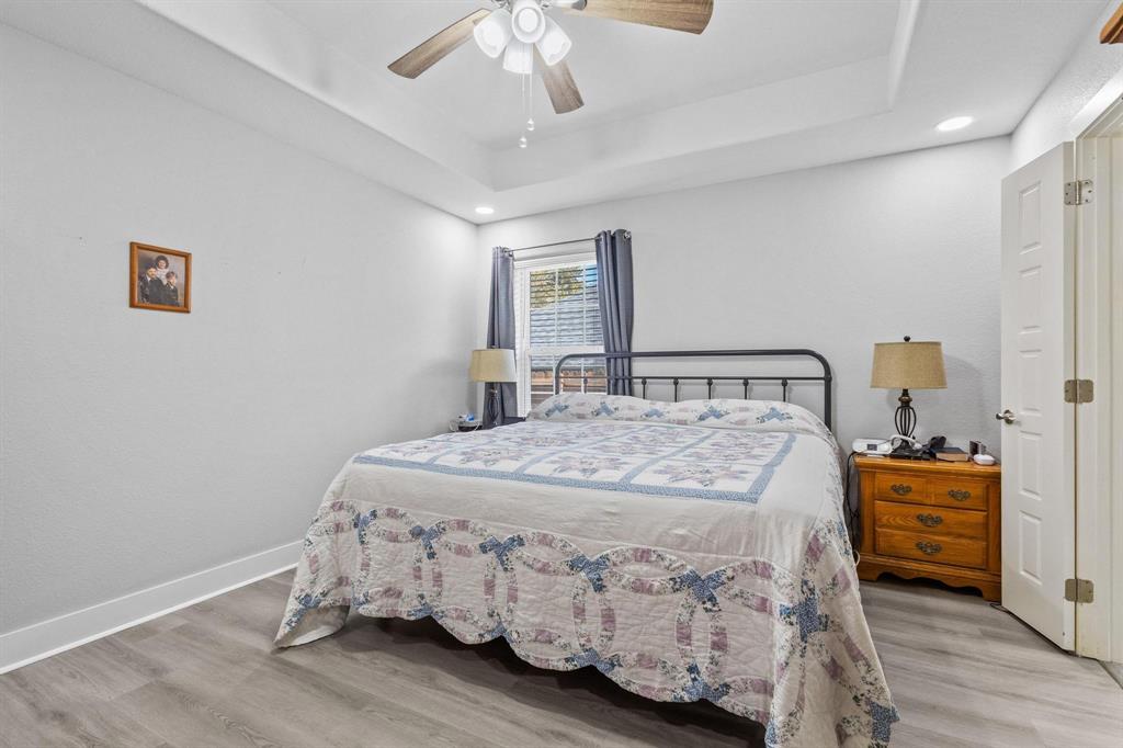 608 East Shepherd Street Denison, TX 75021 - Photo 18 of 31 Room featuring wood-finish flooring, a tray ceiling, recessed lighting, a ceiling fan, and a paneled door