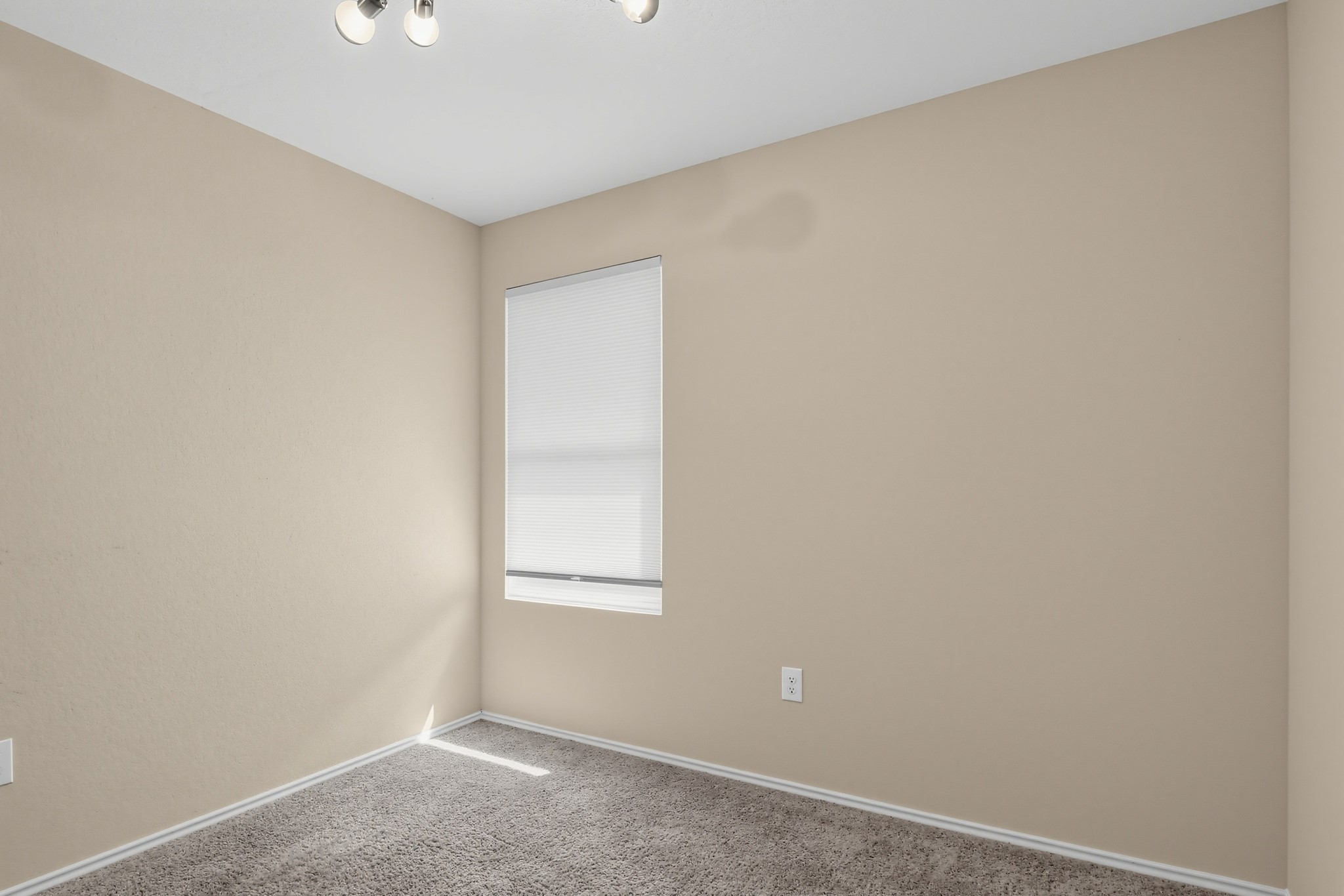 11810 Pyrite Road Manor, TX 78653 - Photo 31 of 38 Plush carpeting and a classic window create a cozy and inviting bedroom space.