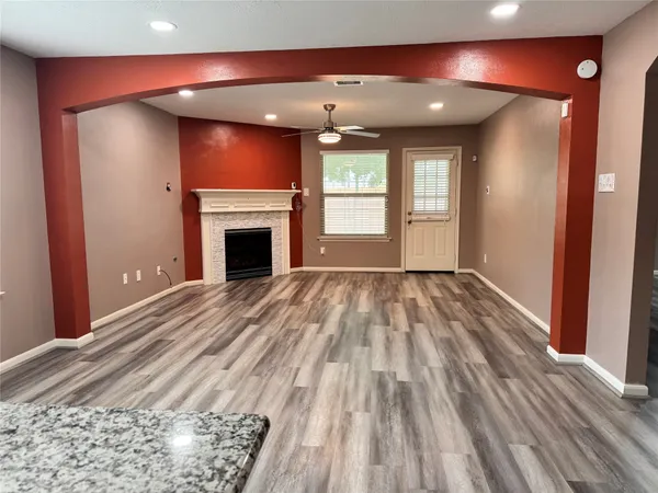 a view of empty room with wooden floor and fireplace