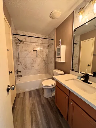 a bathroom with a granite countertop sink toilet a mirror and shower