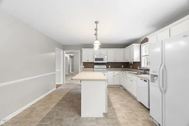 a large kitchen with kitchen island a sink stainless steel appliances and cabinets