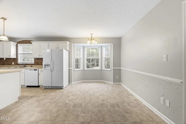 a view of kitchen with refrigerator and window