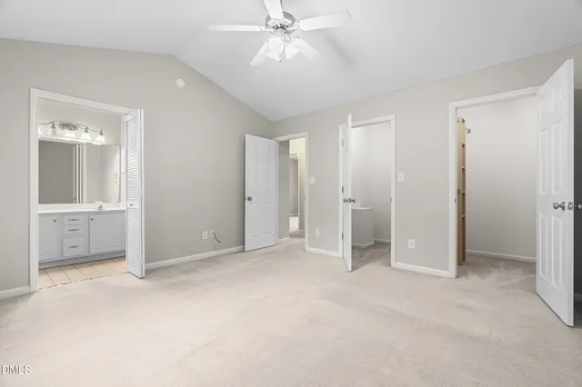 an empty room with closet and a ceiling fan