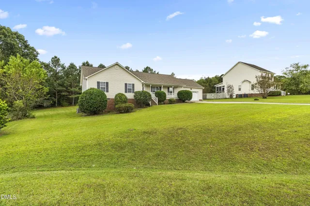 a front view of a house with a garden and yard
