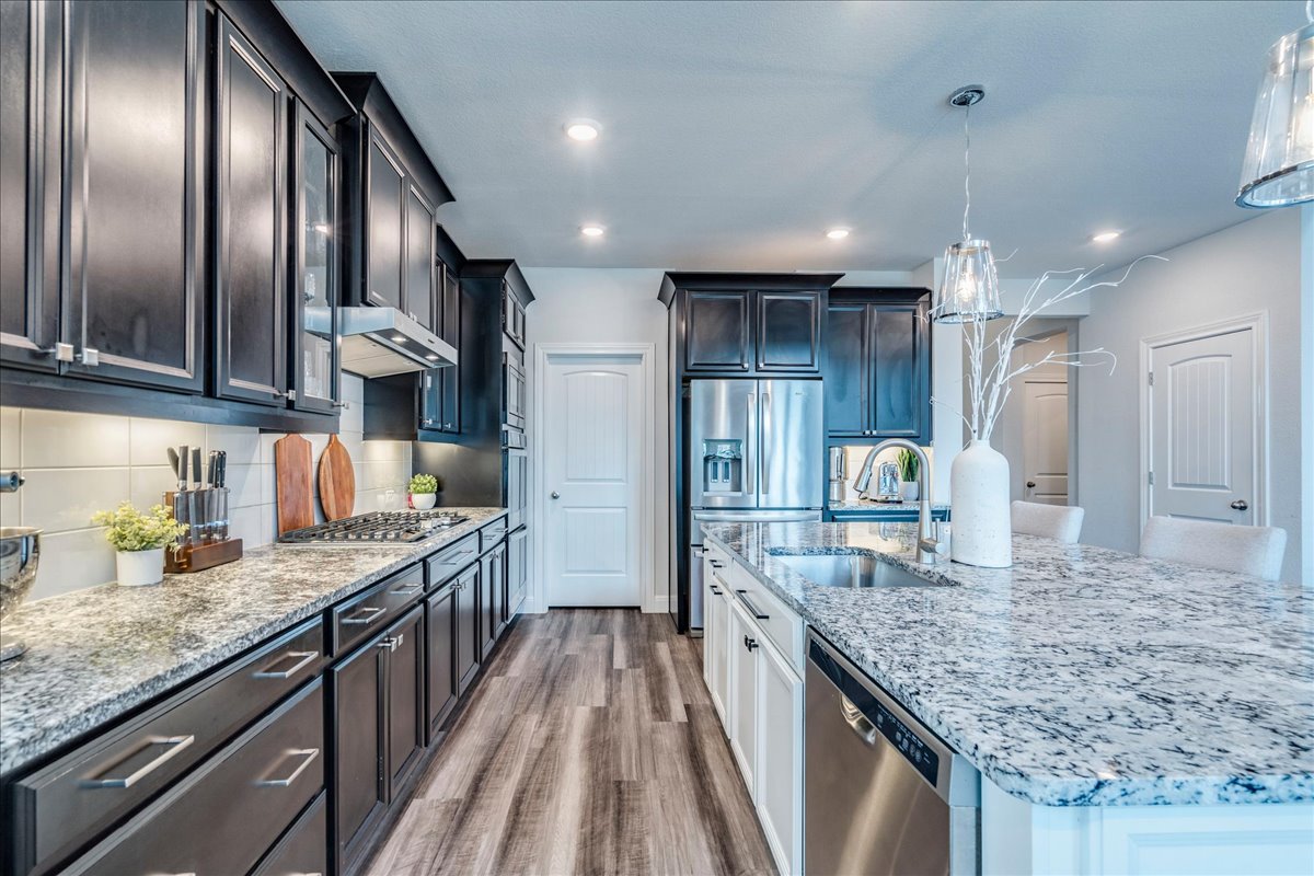 212 Sierra Blanca Road Dripping Springs, TX 78620 - Photo 10 of 37 Open kitchen with gas range and stainless steel appliances.