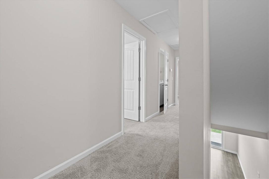 115 Adger Road Pendleton, SC 29670 - Photo 15 of 36 A well-lit second-story hallway with soft carpeting leads to various rooms and a lower level.