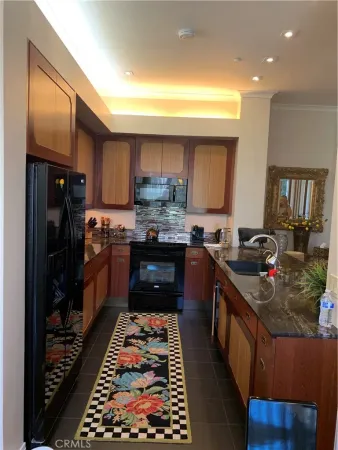 a kitchen with stainless steel appliances granite countertop a stove a sink dishwasher and a refrigerator