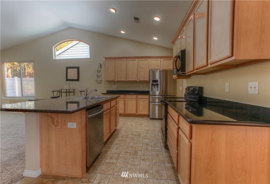 51 Pinehurst Loop Sequim, WA 98382 - Photo 4 of 24 a kitchen with stainless steel appliances granite countertop a sink a stove and a refrigerator