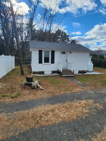 a view of a house with backyard and trees