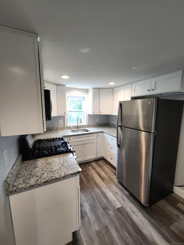 a kitchen with a refrigerator sink and wooden cabinets