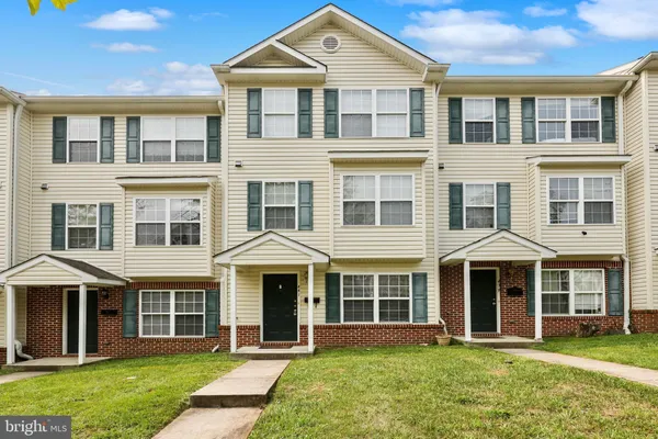 front view of a brick house with a yard