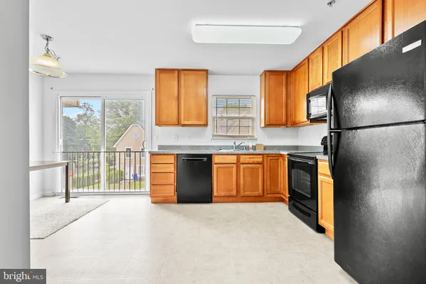 a kitchen with stainless steel appliances granite countertop a refrigerator a sink a stove and a refrigerator