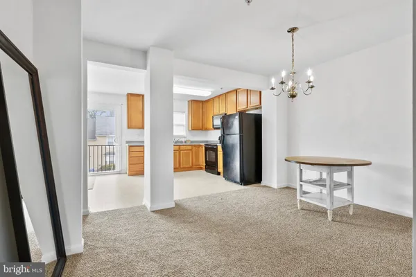 a view of a kitchen with refrigerator and wooden floor