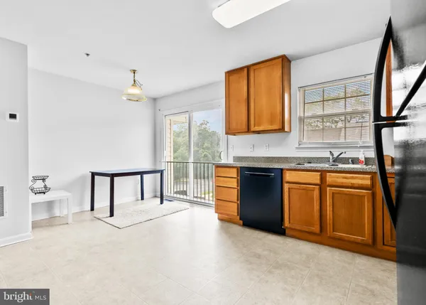 a kitchen with stainless steel appliances granite countertop a sink and a refrigerator