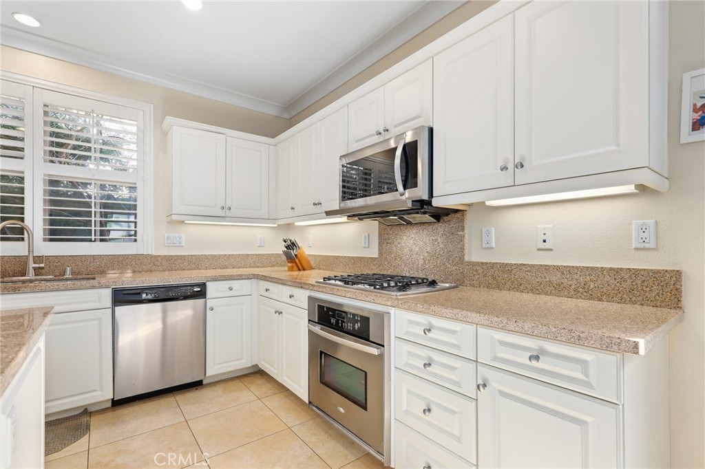 110 Blaze Irvine, CA 92618 - Photo 11 of 28 a kitchen with granite countertop white cabinets and white stainless steel appliances