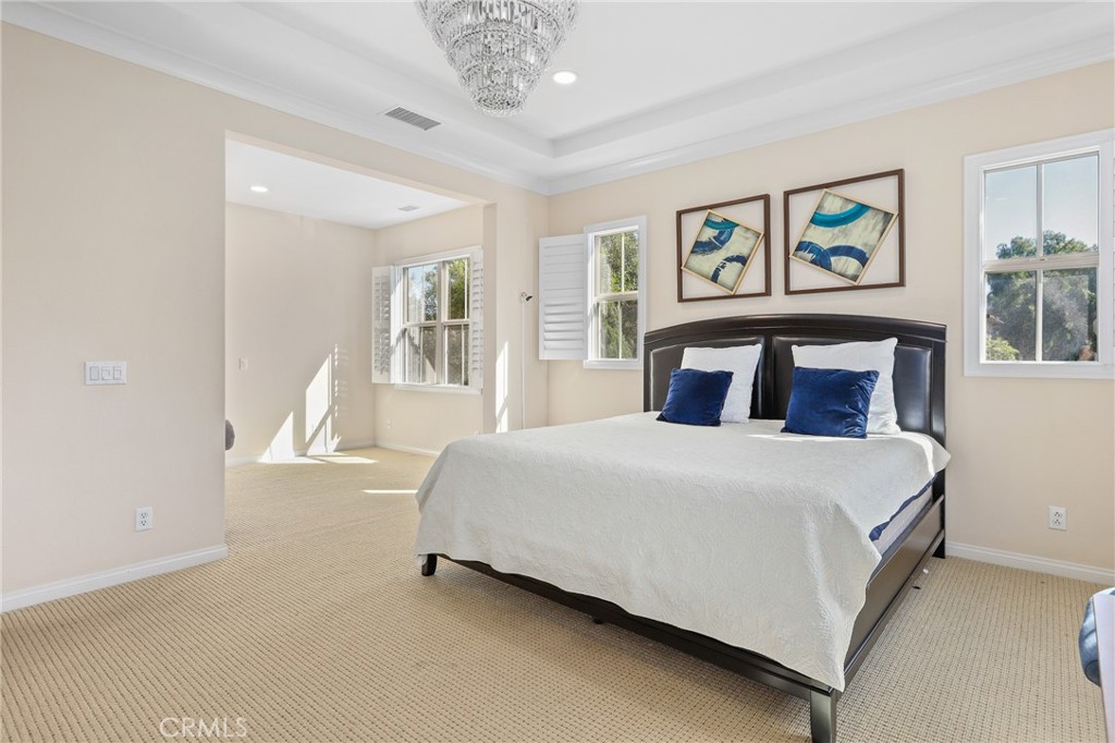 110 Blaze Irvine, CA 92618 - Photo 15 of 28 a bedroom with a large bed and a chandelier