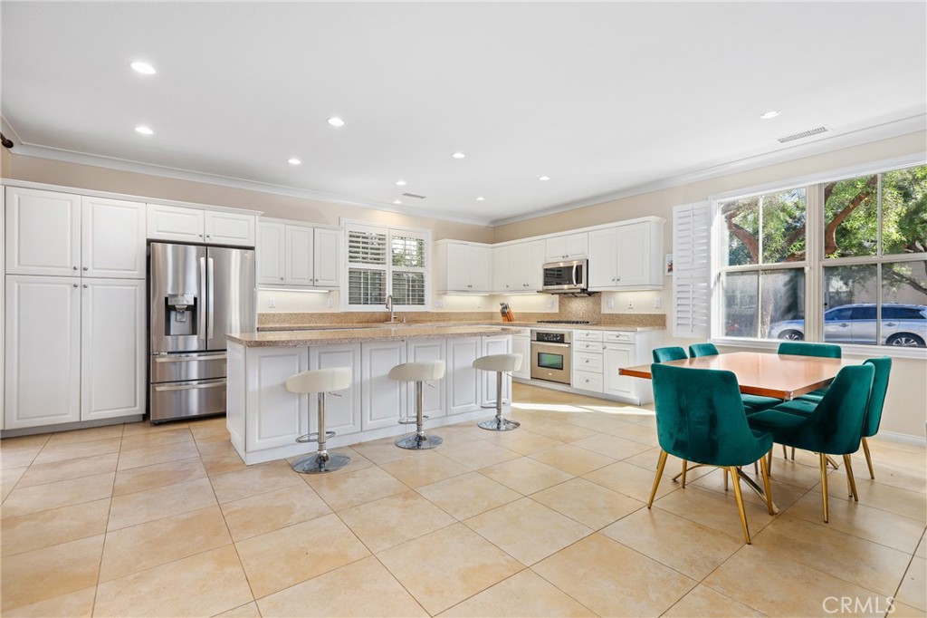 110 Blaze Irvine, CA 92618 - Photo 8 of 28 a kitchen with stainless steel appliances kitchen island granite countertop a refrigerator and cabinets