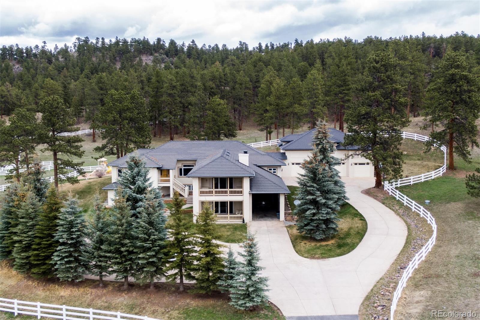 Situated on 22 serene acres, this equestrian estate is private yet convenient to Evergreen shopping and I-70 access.   