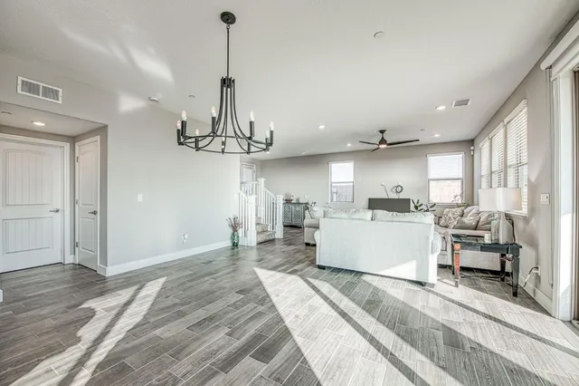 a kitchen with a dining table chairs and wooden floor