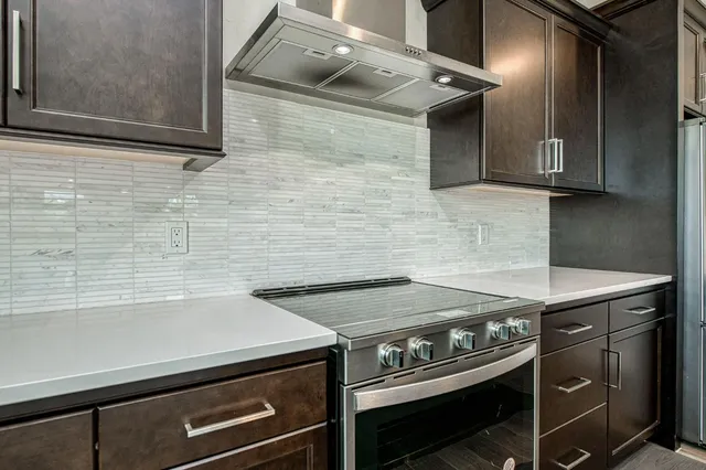 a kitchen with stainless steel appliances granite countertop a sink and a stove