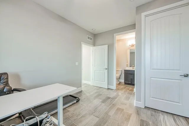 a view of a hallway with wooden floor and entryway