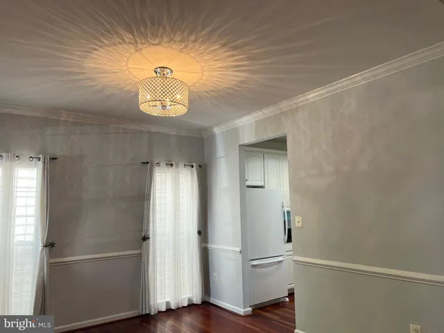 a view of empty room with wooden floor and window