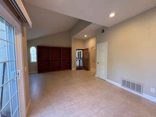 a view of an empty room with a fireplace and a window