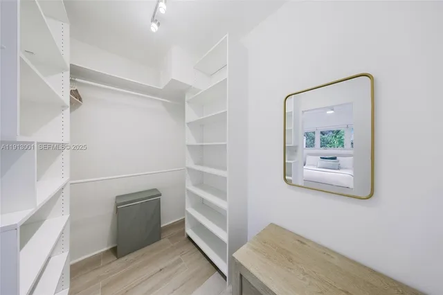 a view of a hallway with wooden floor and cabinet