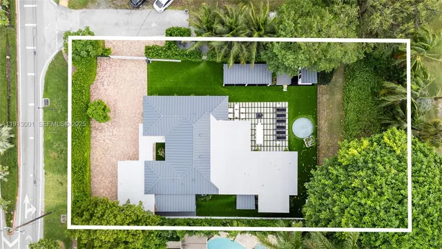 an aerial view of a house with a yard and seating space