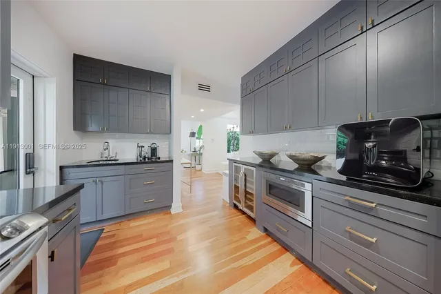 a kitchen with stainless steel appliances granite countertop a stove a sink and a microwave