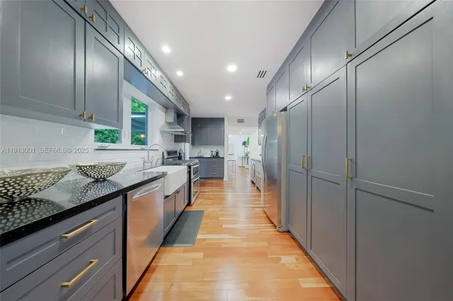 a large kitchen with stainless steel appliances lots of counter top space