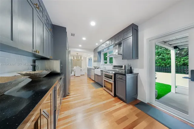 a kitchen with stainless steel appliances granite countertop a stove a sink and a refrigerator