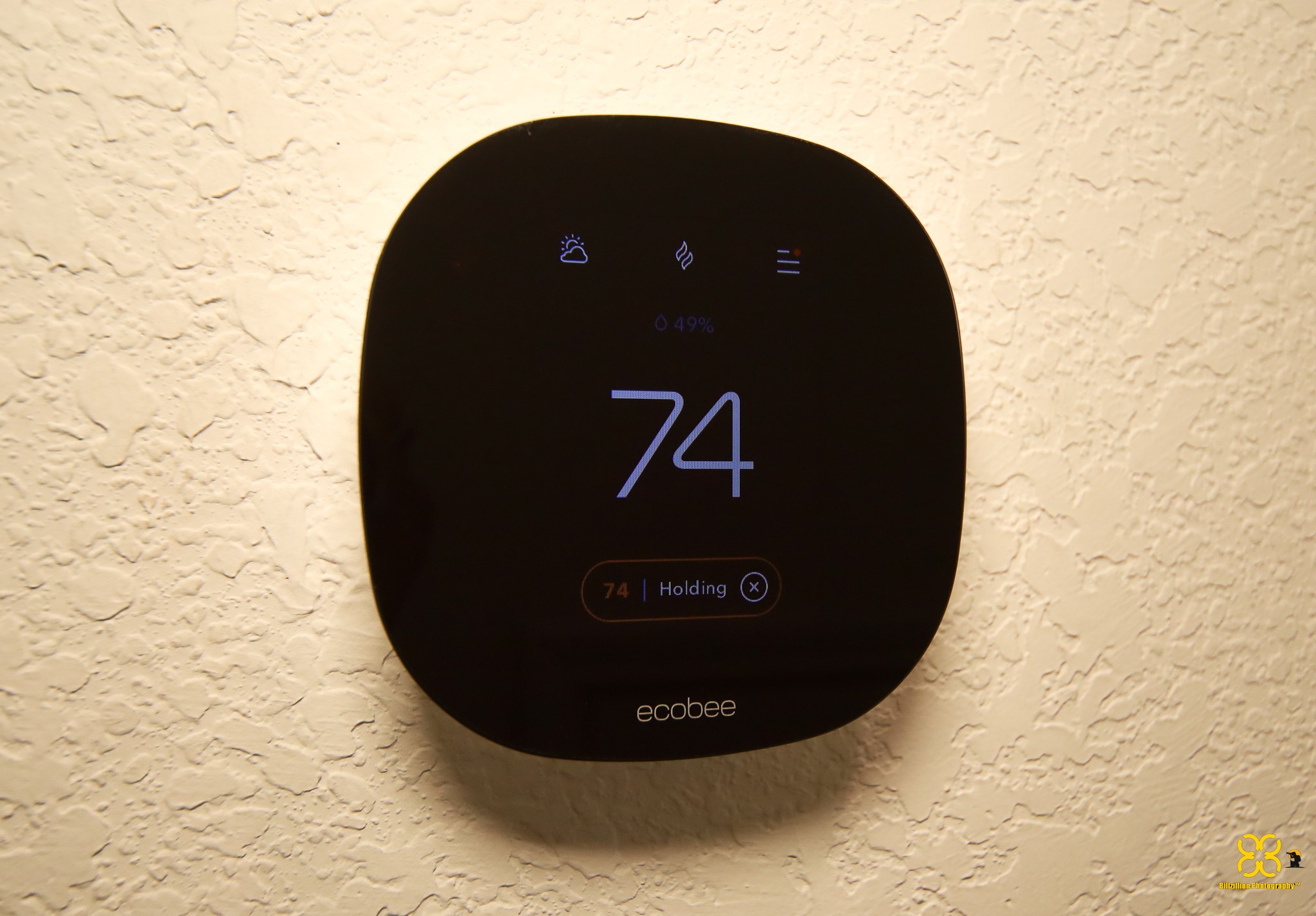 5820 Bluebonnet Lane Rosenberg, TX 77469 - Photo 43 of 43 This photo shows a modern Ecobee smart thermostat mounted on a textured wall, displaying a temperature of 74 degrees.