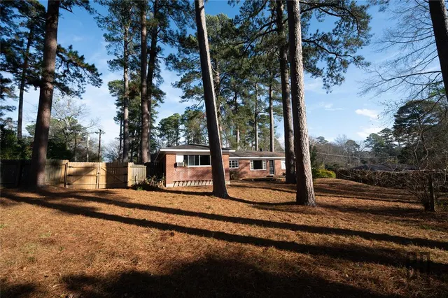 a view of a yard with wooden fence