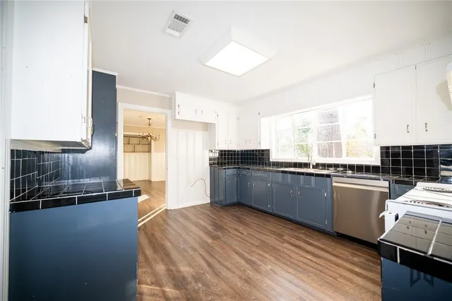 a kitchen with granite countertop a sink cabinets and stainless steel appliances