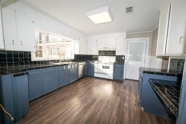 a kitchen with wooden floors and white appliances