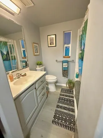 a bathroom with a sink toilet and mirror