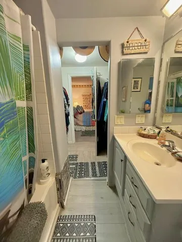 a spacious bathroom with a sink a mirror and shower