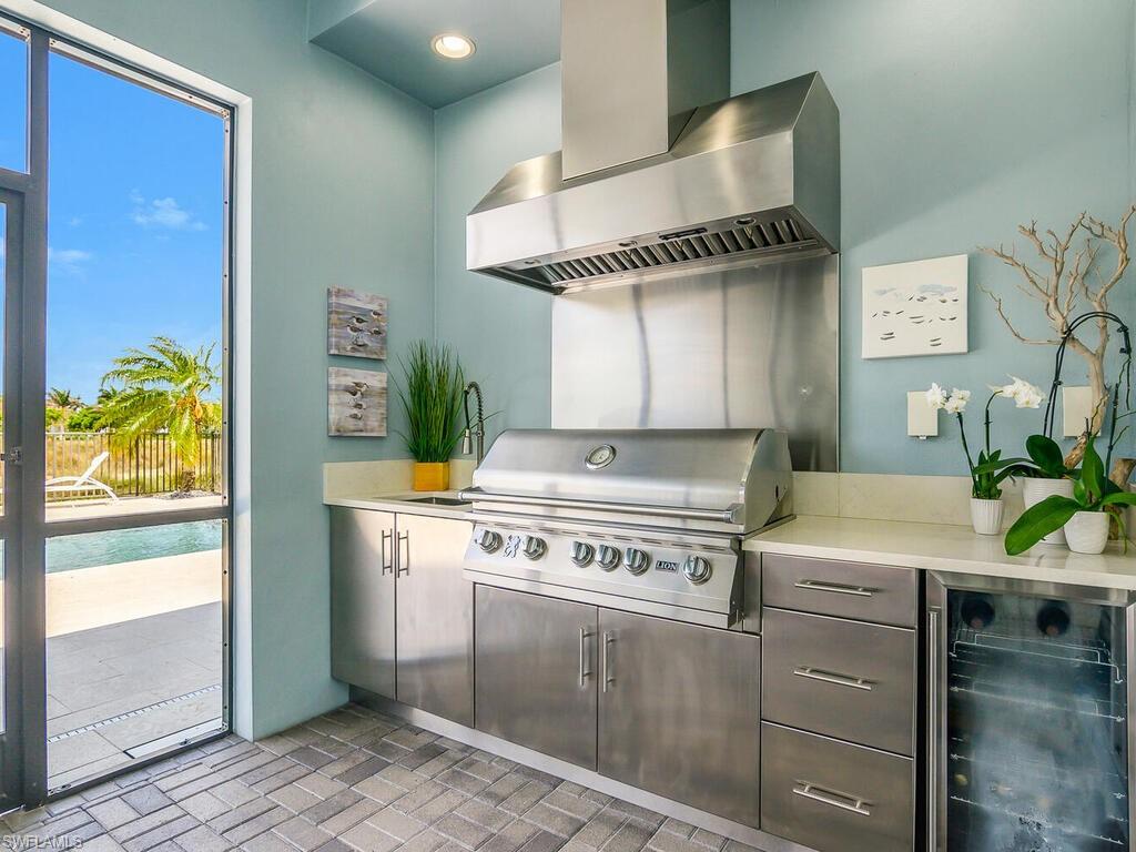 6478 Warwick Avenue Naples, FL 34113 - Photo 11 of 47 a kitchen with a stove and a white wooden cabinets